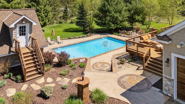 outdoor pool with stairway, a wooden deck, and a patio
