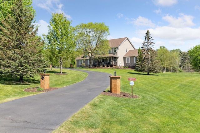 view of front of home with driveway and a front lawn