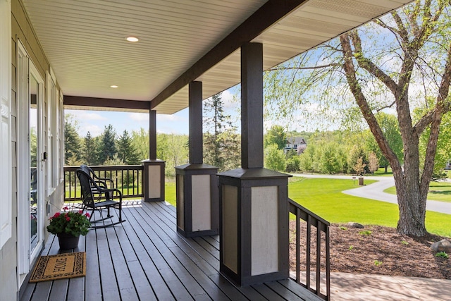 wooden deck featuring a yard and a porch