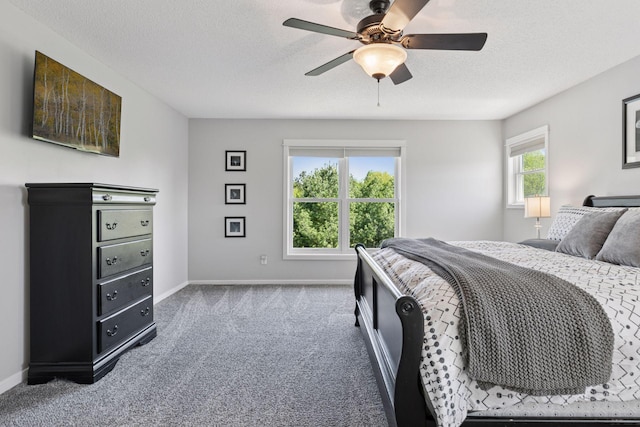 bedroom with carpet, a textured ceiling, baseboards, and a ceiling fan