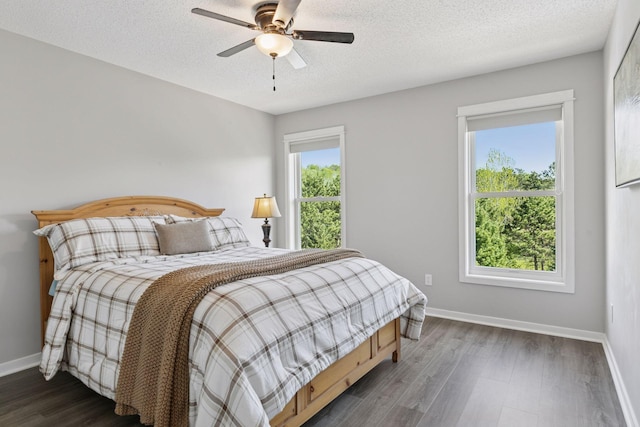 bedroom with baseboards, dark wood-style flooring, a textured ceiling, and ceiling fan