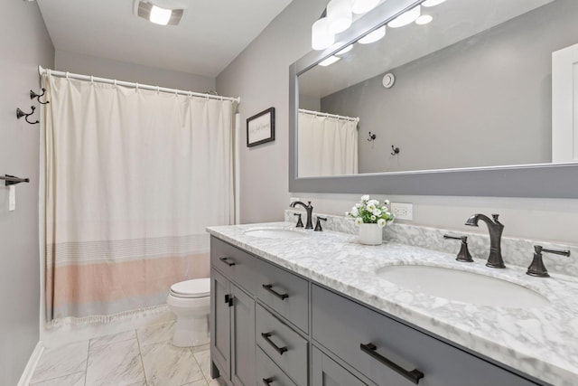 bathroom featuring marble finish floors, double vanity, toilet, and a shower with curtain