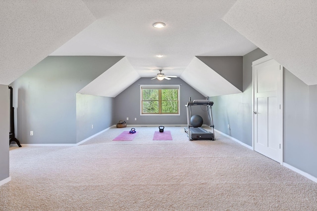 bonus room with carpet, a textured ceiling, baseboards, vaulted ceiling, and a ceiling fan