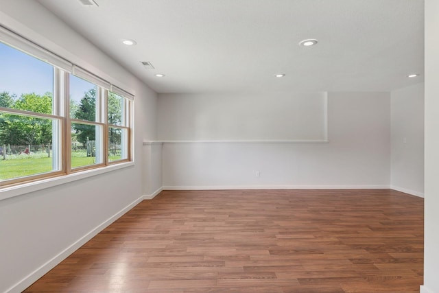 empty room with recessed lighting, wood finished floors, and baseboards