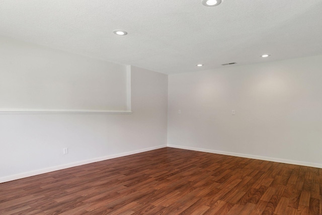 empty room with recessed lighting, wood finished floors, and baseboards