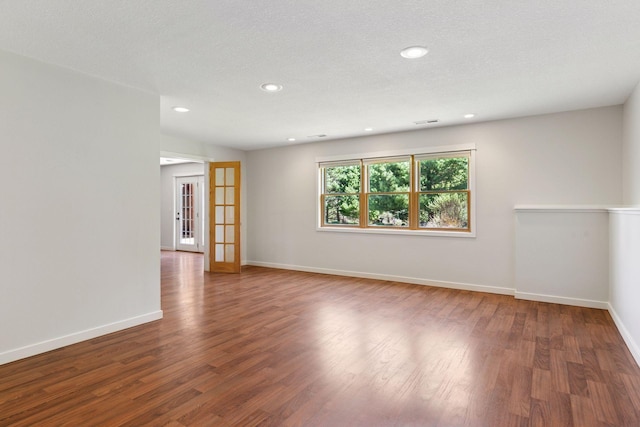empty room featuring french doors, baseboards, wood finished floors, and recessed lighting