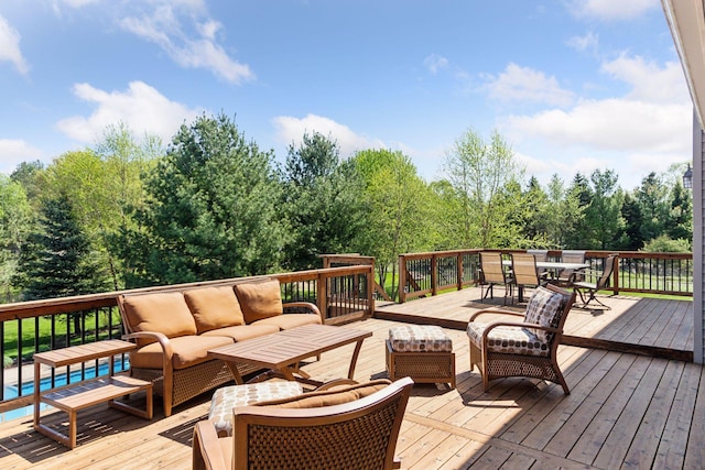 deck with an outdoor hangout area, outdoor dining area, and view of wooded area