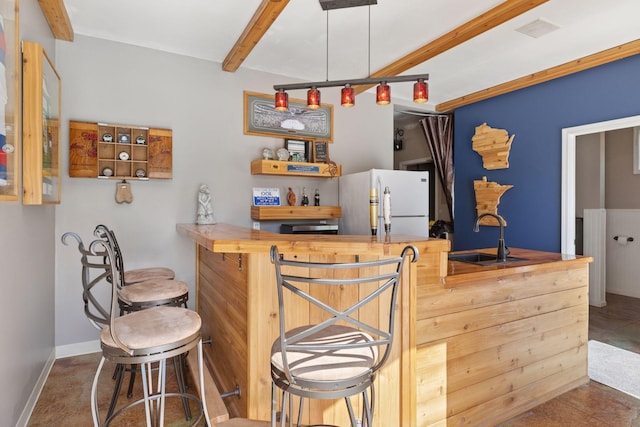 indoor dry bar featuring freestanding refrigerator, beamed ceiling, and baseboards