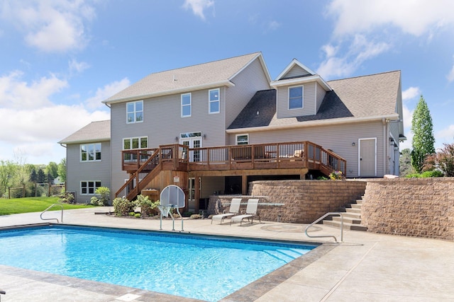 outdoor pool featuring stairs, a wooden deck, and a patio area