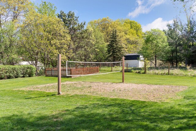 view of property's community with volleyball court and a lawn