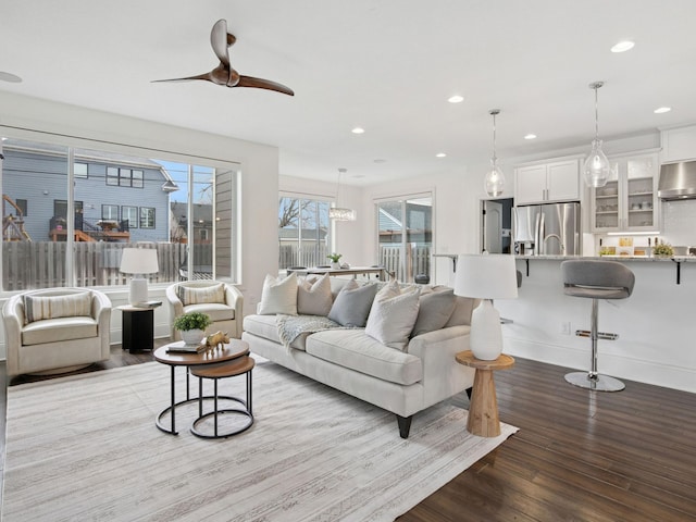 living room featuring a ceiling fan, recessed lighting, wood finished floors, and baseboards