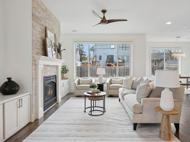 living room with recessed lighting, a large fireplace, wood finished floors, and a ceiling fan