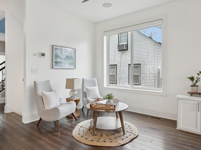 living area featuring visible vents, ceiling fan, baseboards, stairway, and dark wood-style flooring