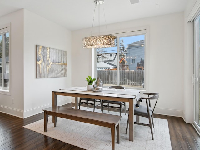 dining space with baseboards and wood finished floors