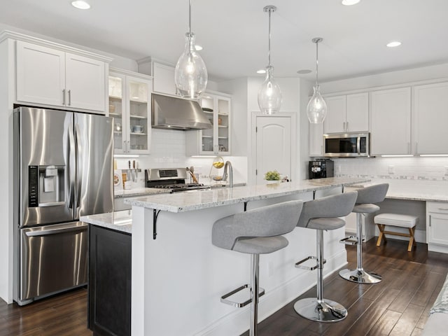 kitchen with under cabinet range hood, dark wood finished floors, appliances with stainless steel finishes, and white cabinets