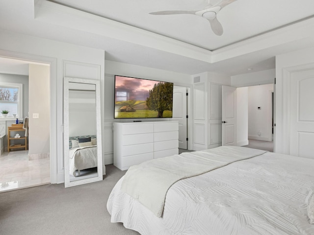 carpeted bedroom with visible vents, ceiling fan, and a tray ceiling