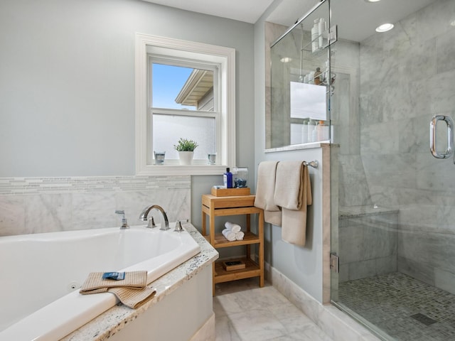 bathroom featuring baseboards, a bath, and a shower stall