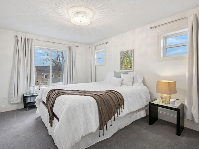 carpeted bedroom featuring multiple windows and a textured ceiling