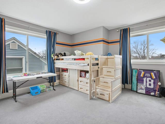 bedroom featuring carpet flooring, multiple windows, and a textured ceiling