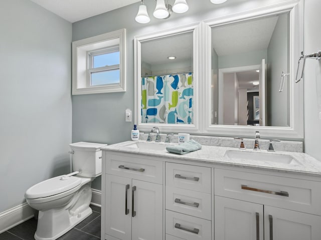 full bathroom featuring a sink, baseboards, toilet, and double vanity