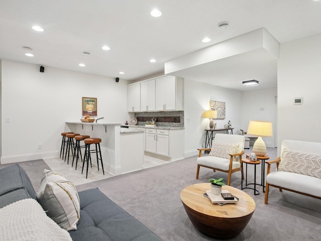 living room with light colored carpet, recessed lighting, and baseboards