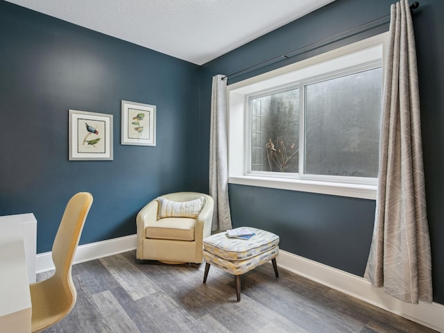 living area with baseboards and wood finished floors