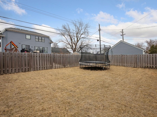 view of yard with a trampoline and a fenced backyard