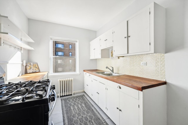 kitchen featuring tasteful backsplash, sink, radiator, white cabinetry, and black gas range oven