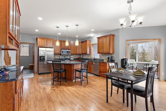 kitchen featuring a kitchen island, stainless steel appliances, hanging light fixtures, and a chandelier