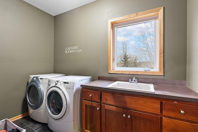 laundry area with sink, cabinets, a textured ceiling, washer and clothes dryer, and dark tile patterned flooring