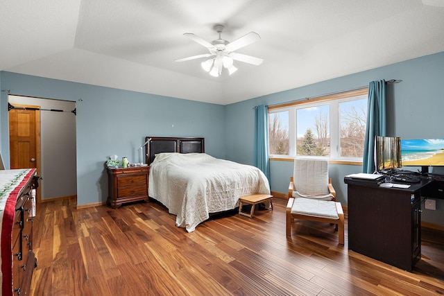 bedroom with ceiling fan, dark hardwood / wood-style flooring, and lofted ceiling