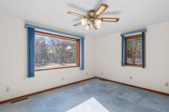 empty room featuring ceiling fan and carpet