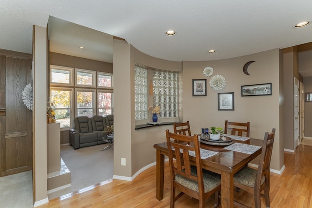 dining area featuring a textured ceiling and light wood-type flooring