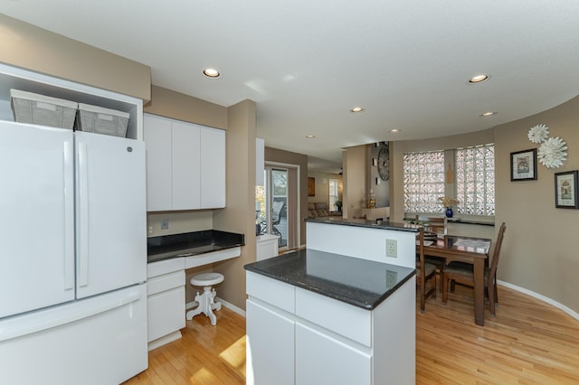 kitchen featuring white cabinetry, light hardwood / wood-style floors, and white refrigerator