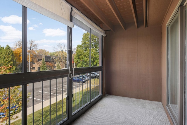 unfurnished sunroom with beamed ceiling