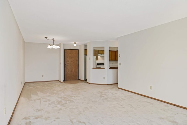 unfurnished living room with carpet and a notable chandelier