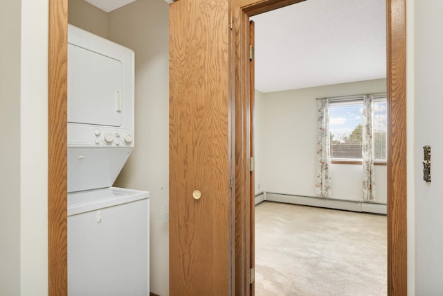 laundry area featuring light carpet, a baseboard heating unit, and stacked washing maching and dryer