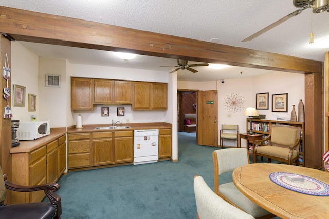 kitchen with sink, white appliances, ceiling fan, dark colored carpet, and beamed ceiling