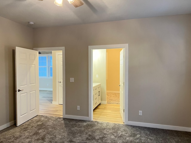 unfurnished bedroom with light carpet, connected bathroom, and ceiling fan