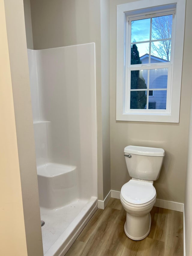 bathroom featuring walk in shower, toilet, and hardwood / wood-style floors