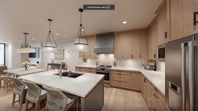 kitchen with wall chimney exhaust hood, light wood-type flooring, light brown cabinetry, sink, and appliances with stainless steel finishes