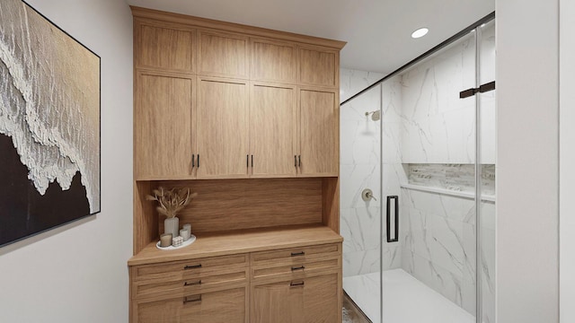 bathroom featuring a shower with door and vanity