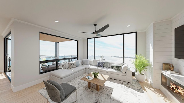 living room featuring light hardwood / wood-style floors, ornamental molding, a large fireplace, and a water view