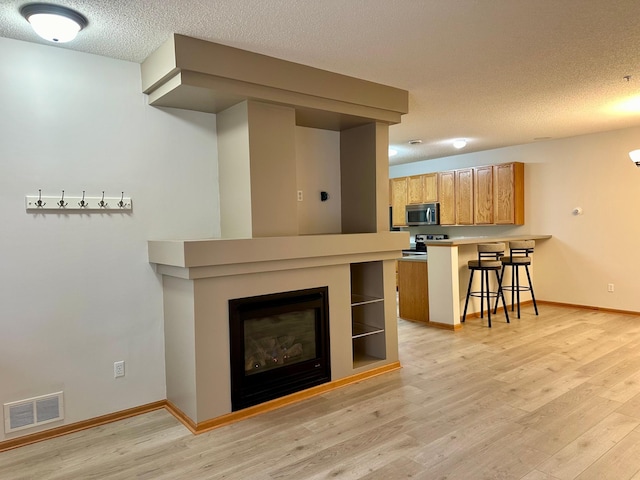 living room featuring a textured ceiling and light hardwood / wood-style flooring