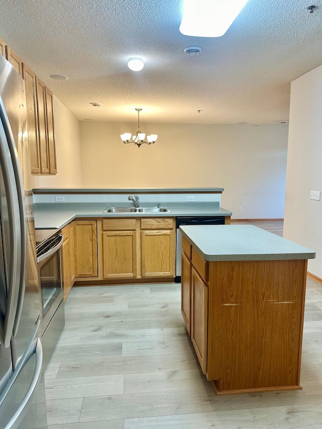 kitchen featuring a notable chandelier, light hardwood / wood-style floors, stainless steel appliances, and hanging light fixtures