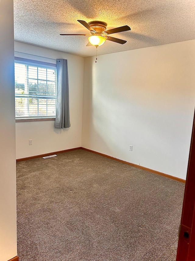 carpeted empty room with a textured ceiling and ceiling fan