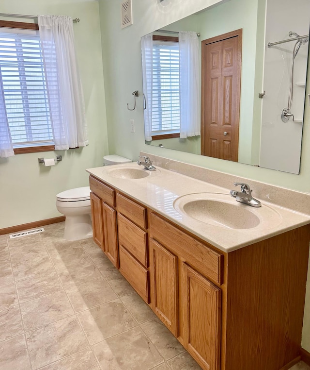 bathroom with tile patterned flooring, vanity, and toilet