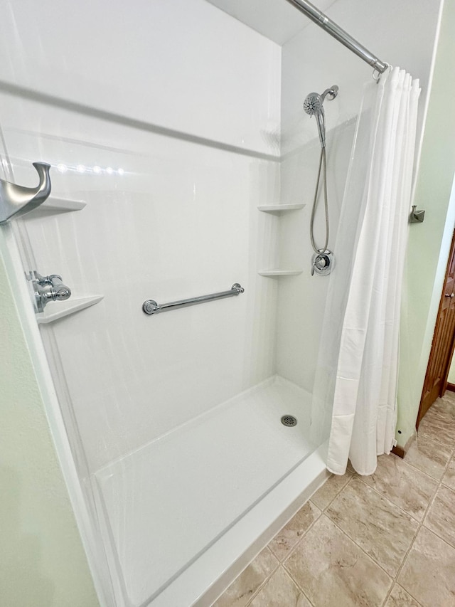 bathroom with tile patterned floors and walk in shower