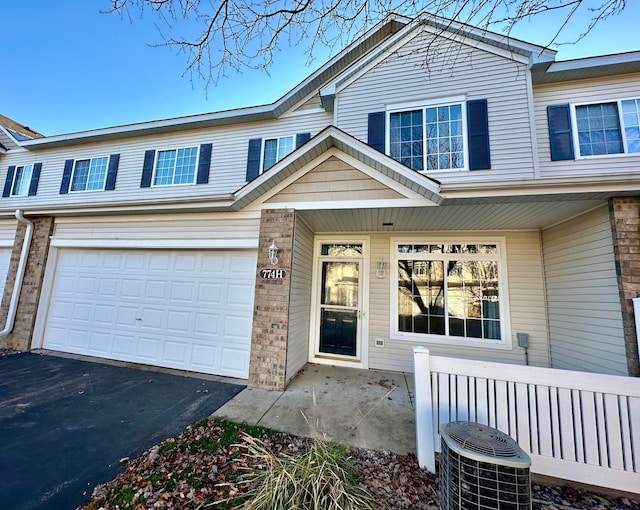 view of front of property with a garage and central AC unit