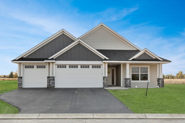 craftsman inspired home featuring a front yard and a garage